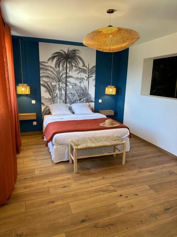 菲加里La poudrière的一间卧室配有一张大床和一个吊灯。