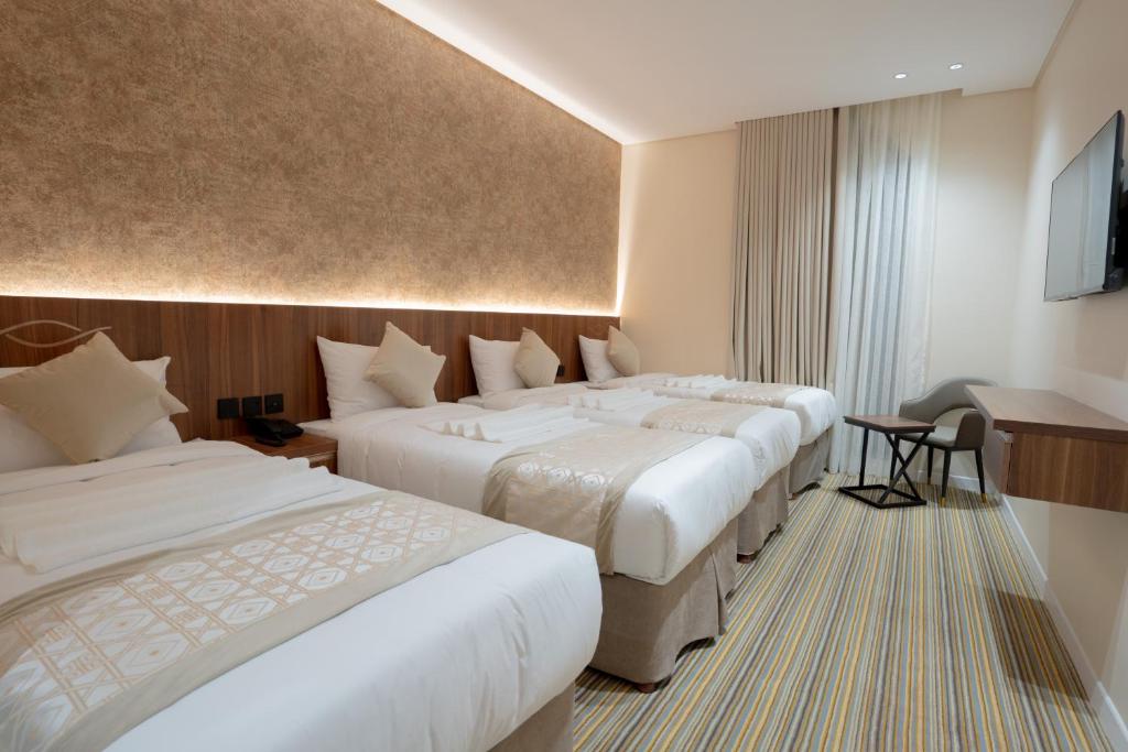 Ajyadفندق روحة المقام的酒店客房设有三张床和电视。