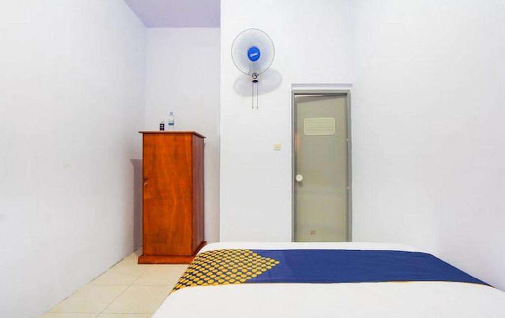 RogojampiHomestay的一间卧室配有一张蓝色和黄色毯子的床
