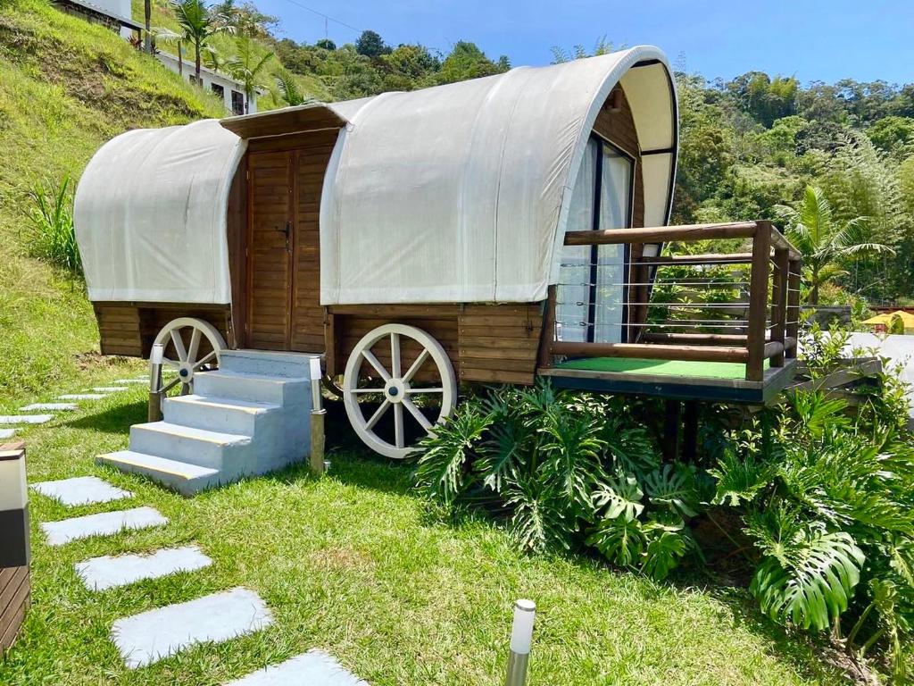 瓜塔佩Glamping La Cepa GUATAPÉ的山顶上带盖子的木车