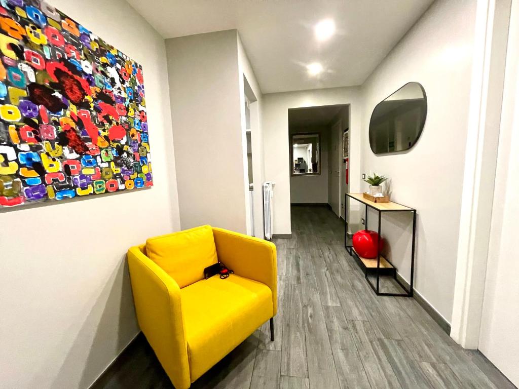 罗马Your House By Ale的走廊上的黄色椅子,墙上有绘画作品