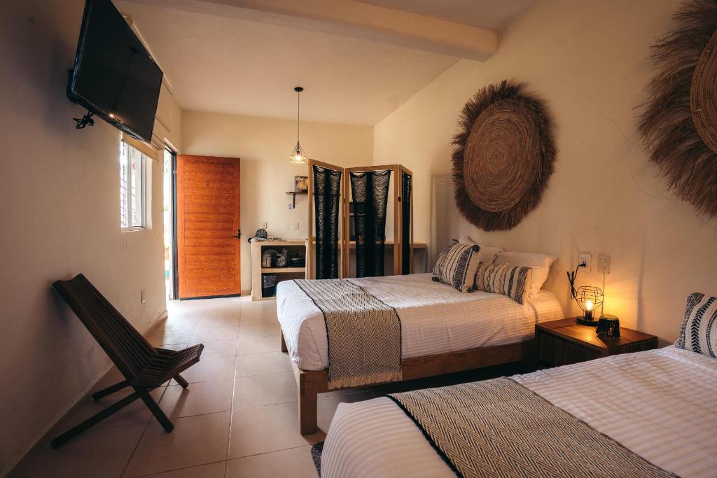 萨尤利塔Nuiya Hoteles Centro的一间卧室配有两张床和一台平面电视