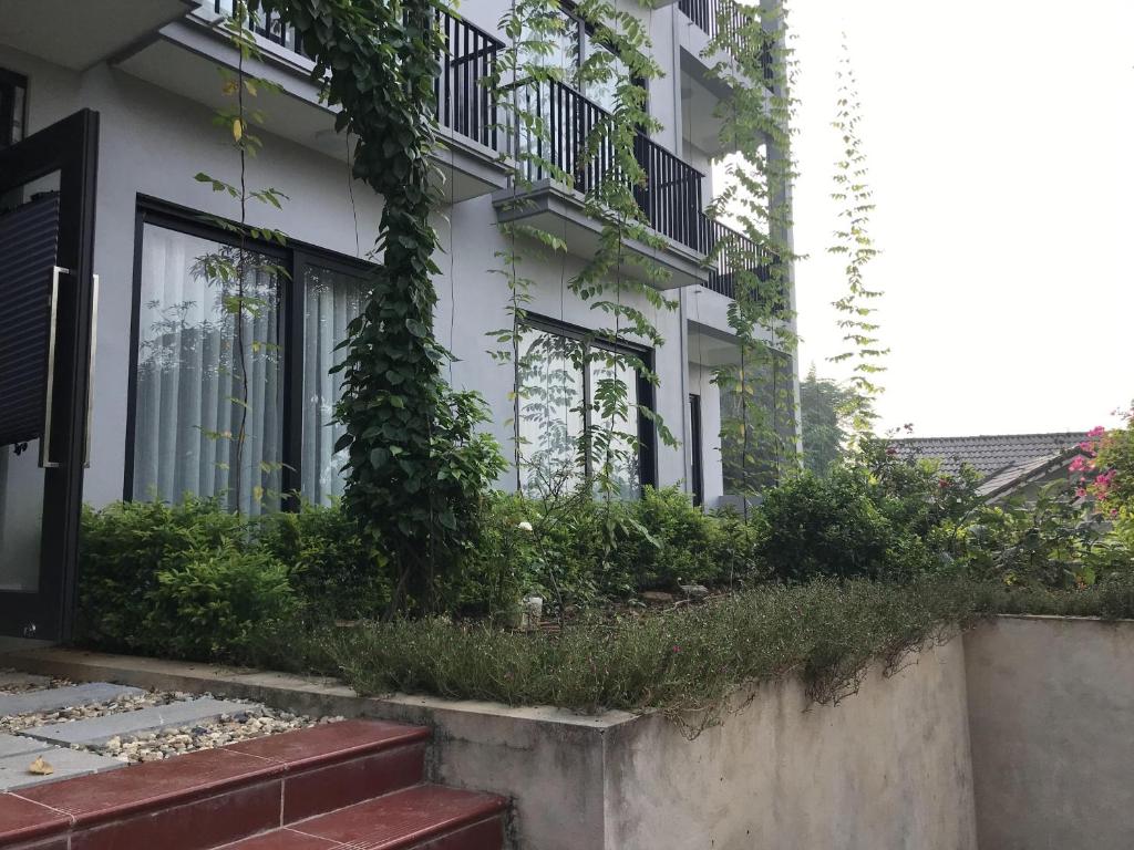 Việt TrìThái Dương Hotel的白色的建筑,旁边是植物