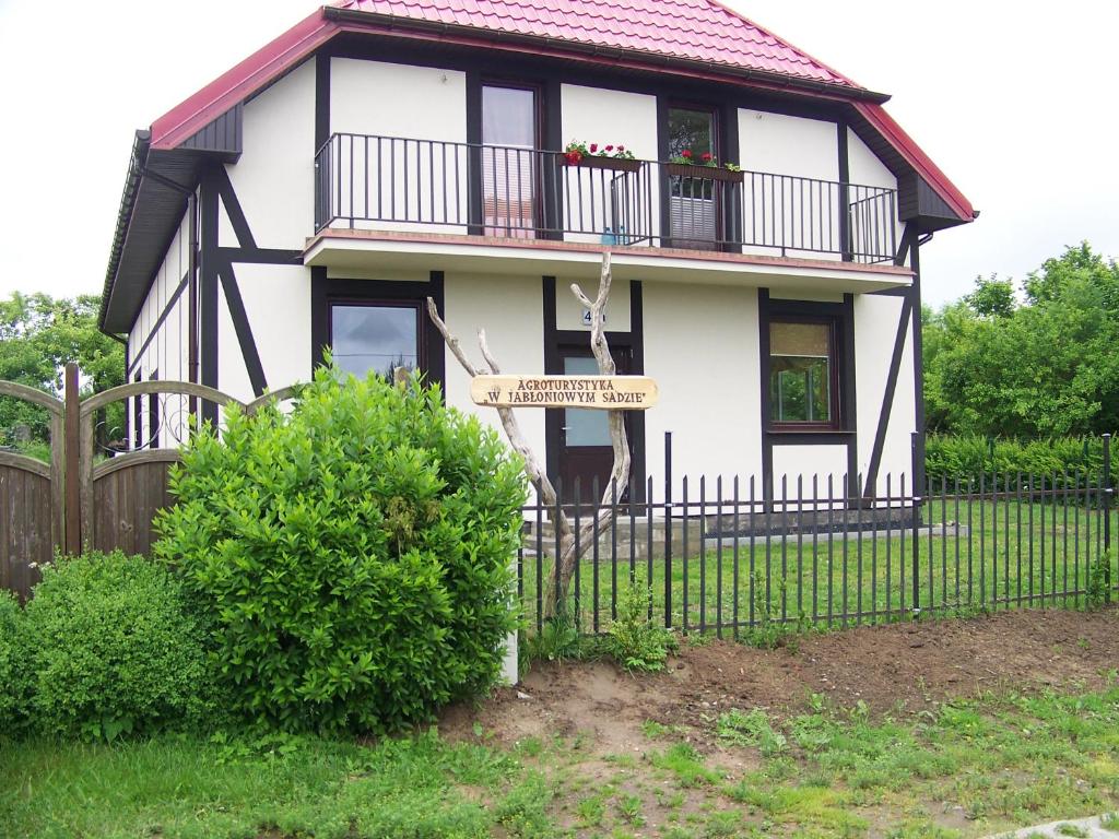 JeżyceAgroturystyka W Jabłoniowym Sadzie的带阳台和围栏的白色房屋