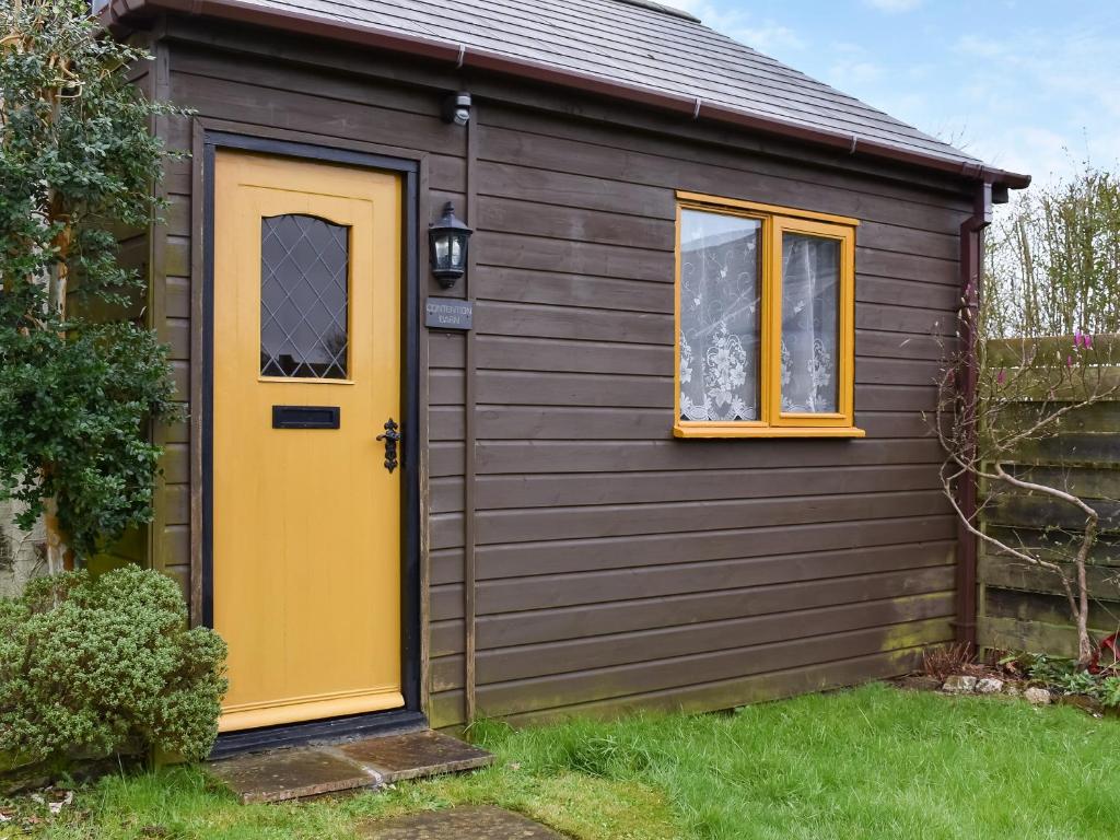 佩伦波斯Contention Barn的一个小棚子,有一个黄色的门和窗户