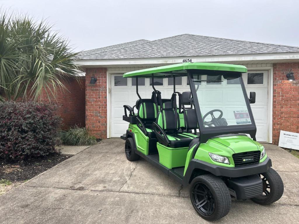 德斯坦WINDSTARR DESTIN- Golf Cart Included, One level, Close to beach, Pet friendly的停在房子前面的绿色高尔夫球车