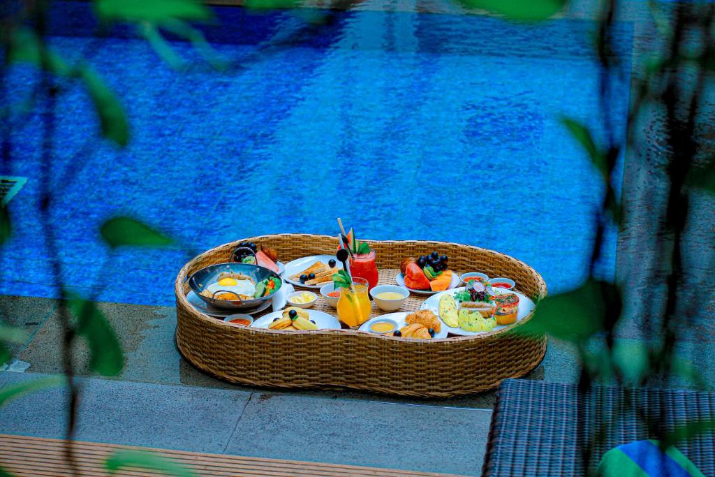 库塔瑞士贝莱克斯库塔勒吉安酒店的游泳池畔桌子上的一篮子食物
