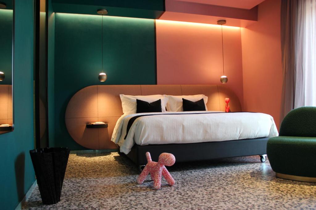 诺拉NOLA BOUTIQUE HOTEL - self check-的一间卧室配有一张大床和粉红色泰迪熊