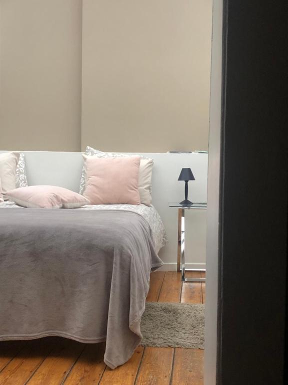 通厄伦Tongeren Schuttersgang 1的一间卧室配有一张带粉红色枕头的床和一张桌子