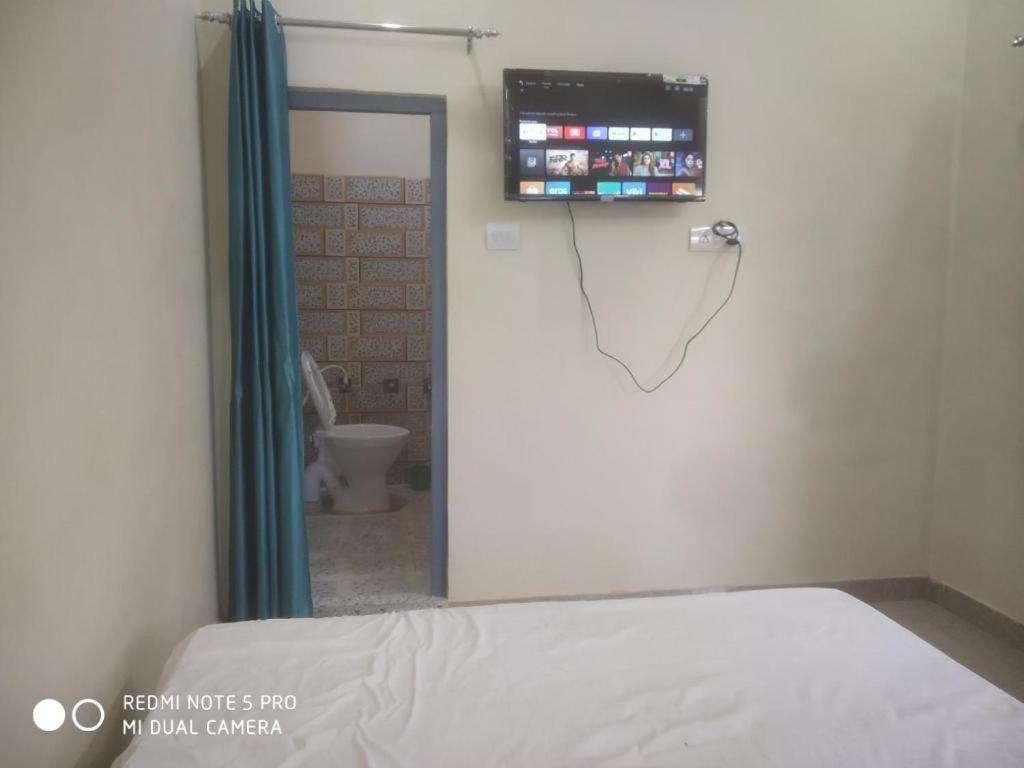 KannaujBraj Waterpark & Resort的一间医院房间,里面设有一张床和墙上的电视