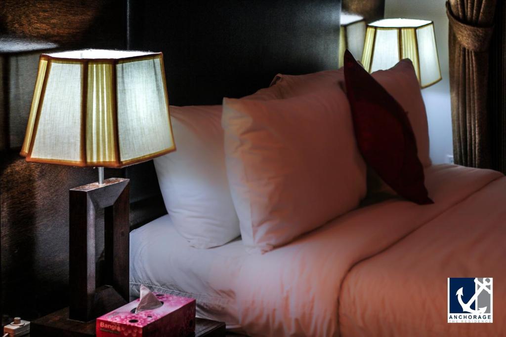 达卡安克雷奇酒店的一间卧室配有一张带枕头的床和两盏灯。