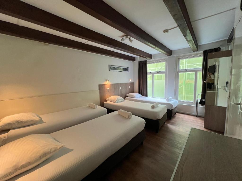 阿姆斯特丹老城区酒店的酒店客房设有三张床和窗户。