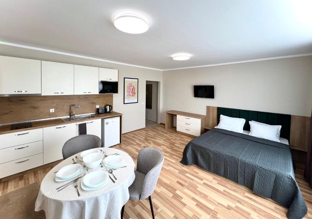 圣弗拉斯西内瓦太阳海岸公寓式酒店的一间卧室配有一张床和一张桌子及椅子