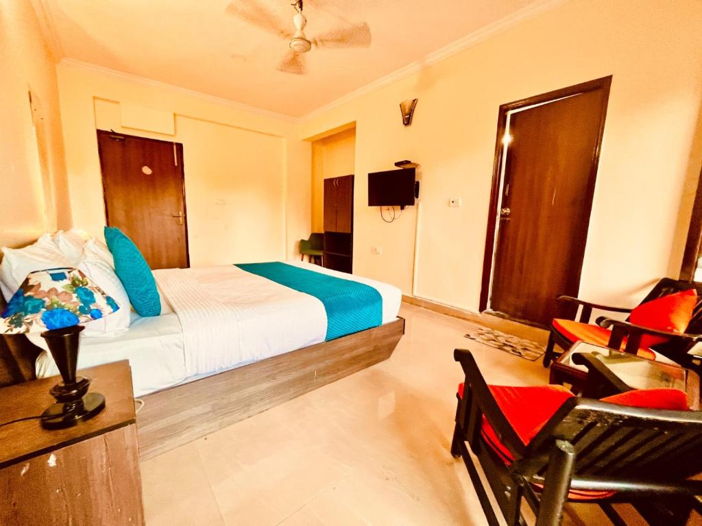 卡兰古特Hotel Shivam Inn - Near Calangute Beach的卧室配有一张床、一张桌子和椅子