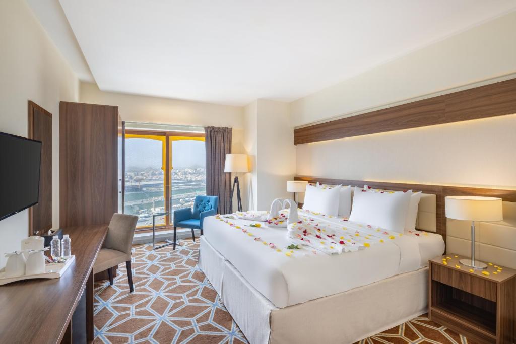 麦加Blue Coral Hotel的酒店客房设有一张大床和一张书桌。