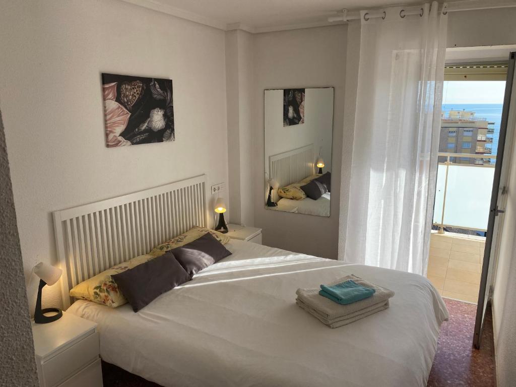 马雷尼布劳High-Floor Bright Apartment with Sea Views的一间带一张白色大床的卧室和一个阳台