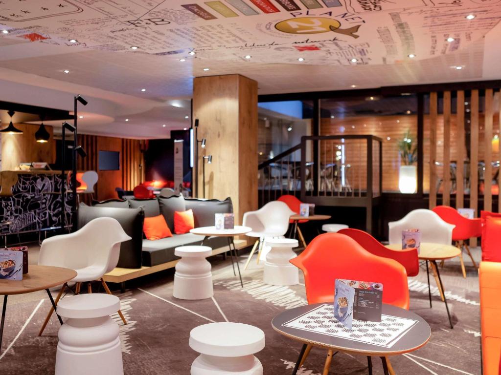 里昂里昂巴迪火车站宜必思酒店的一间设有白色椅子和桌椅的餐厅