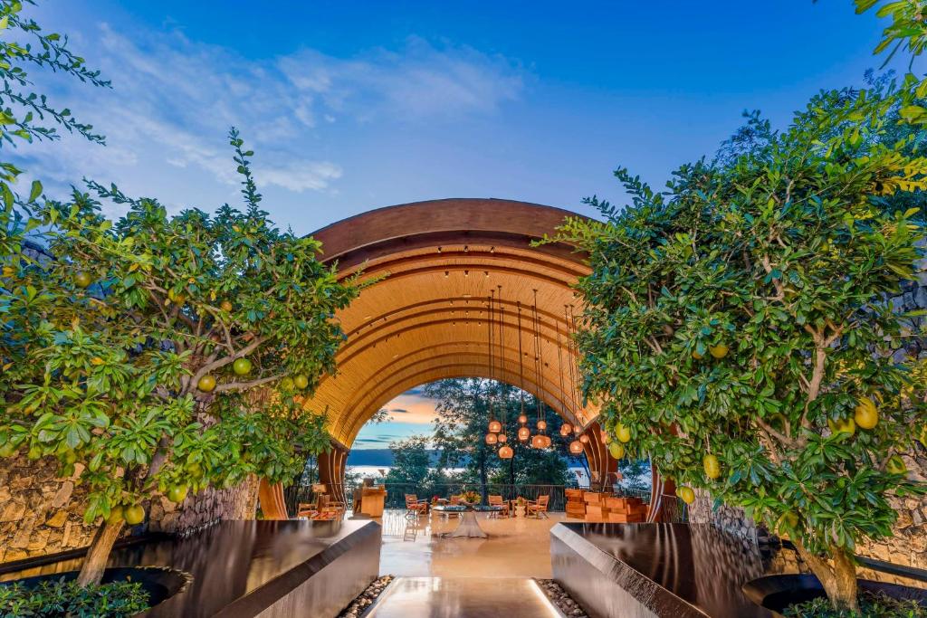 Culebra哥斯达黎加帕帕加约半岛度假村凯悦概念安达仕酒店的一座拱形建筑,有树和桌子
