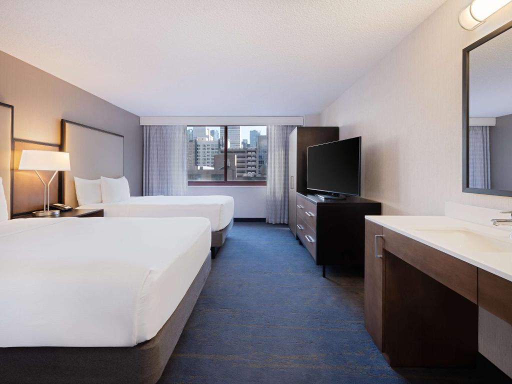 芝加哥Embassy Suites Chicago - Downtown River North的酒店客房设有两张床和盥洗盆