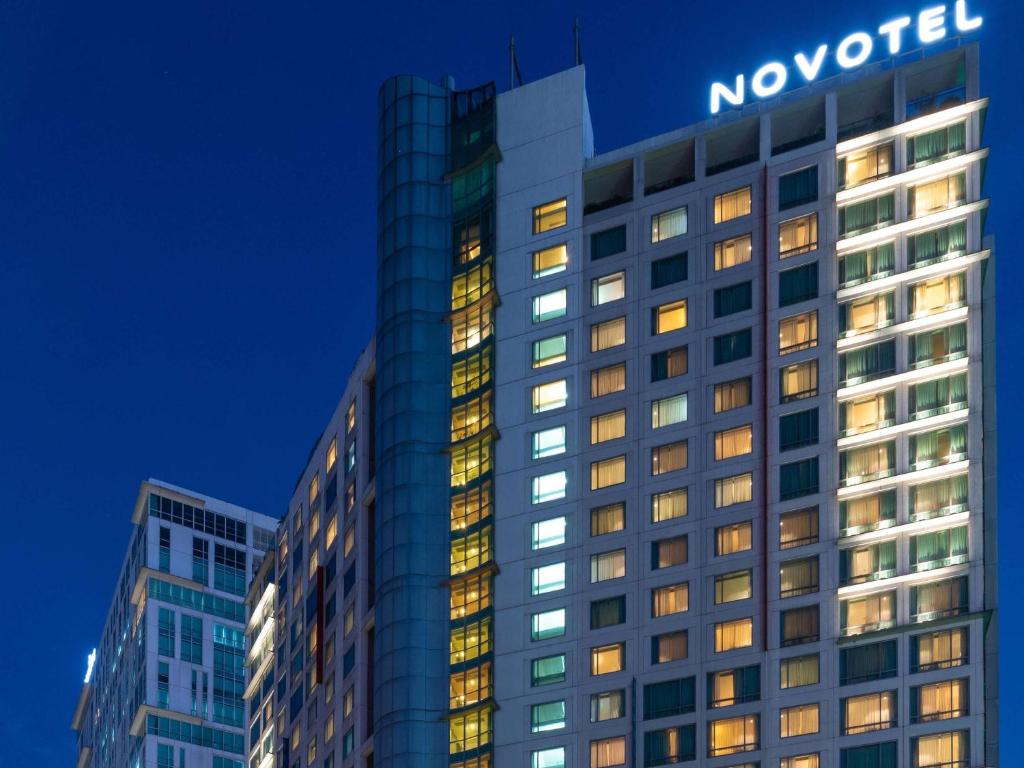马尼拉Novotel Manila Araneta City Hotel的顶部有领座标志的建筑