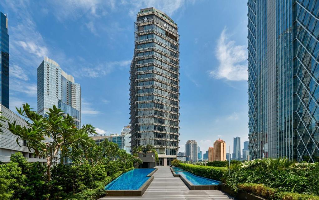 雅加达Alila SCBD Jakarta的一座高大的建筑,在城市里设有游泳池