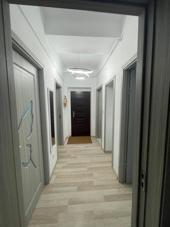 巴克乌E&N ACCOMMODATION的走廊的走廊,设有白色的墙壁和木地板