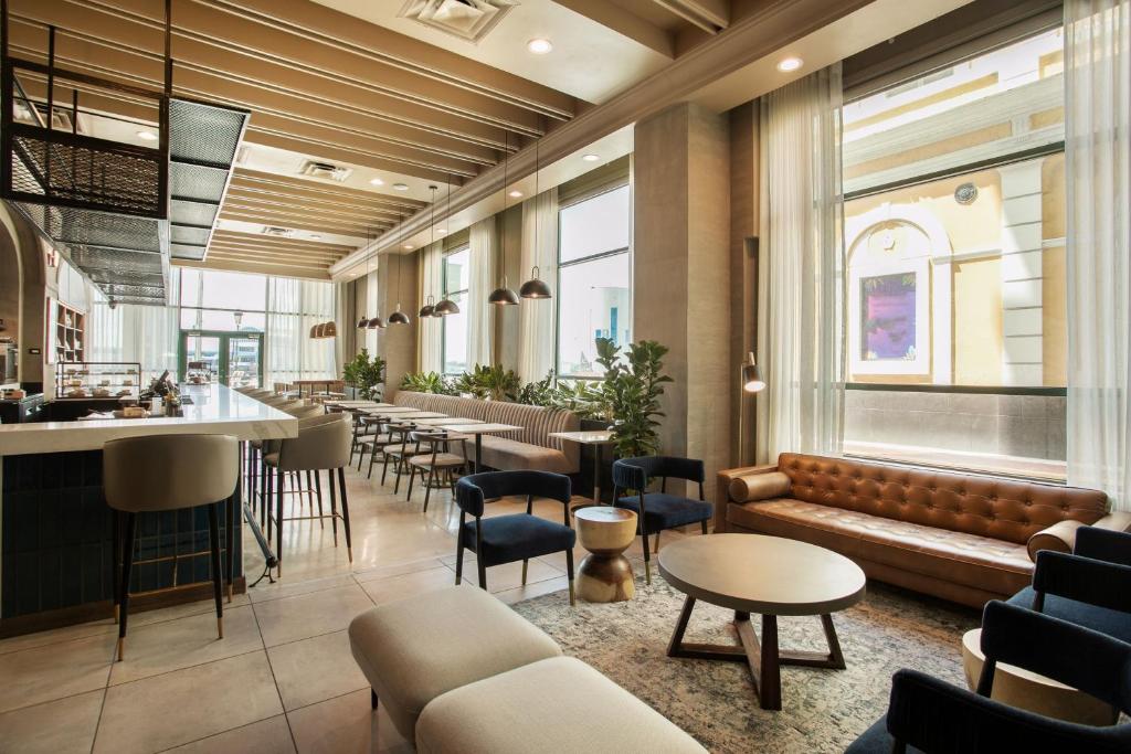 圣胡安Hotel Rumbao, a Tribute Portfolio Hotel的一间带沙发和桌子的餐厅和一间酒吧