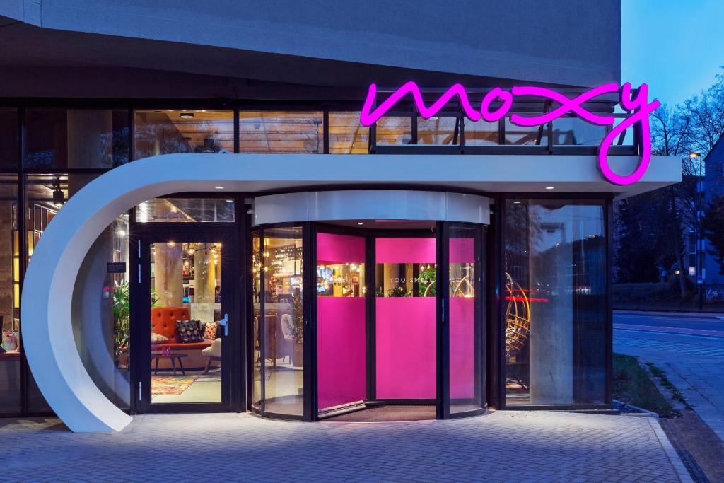 哥伦比亚Moxy Columbia Downtown的粉红色门和 ⁇ 虹灯的前方
