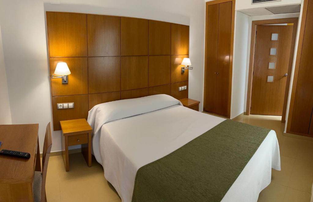 佩尼斯科拉瑞虎佩佩酒店的卧室设有白色大床和木墙