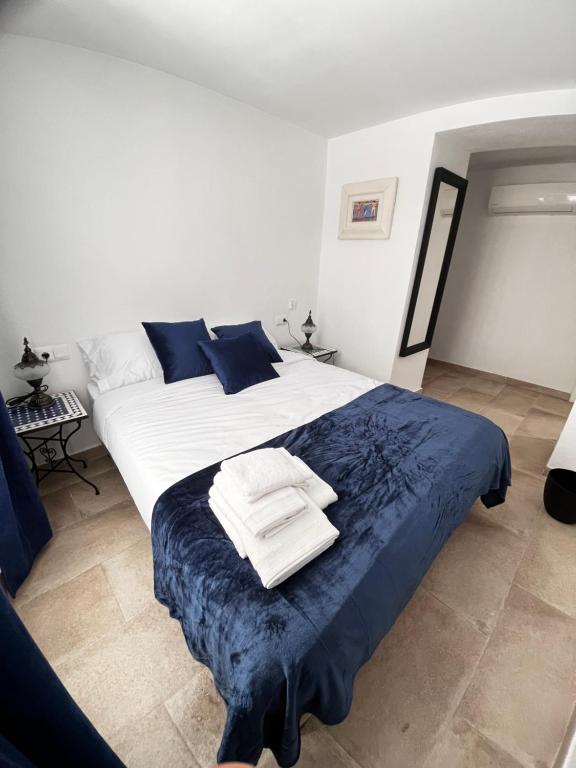 马拉加Shanti’s Andalusian Rooms的卧室配有一张大白色的蓝色床单