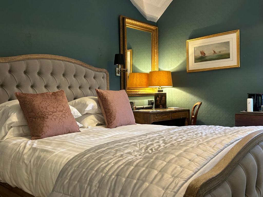 哈罗盖特贝特里楼酒店的一间卧室配有一张带镜子的大床