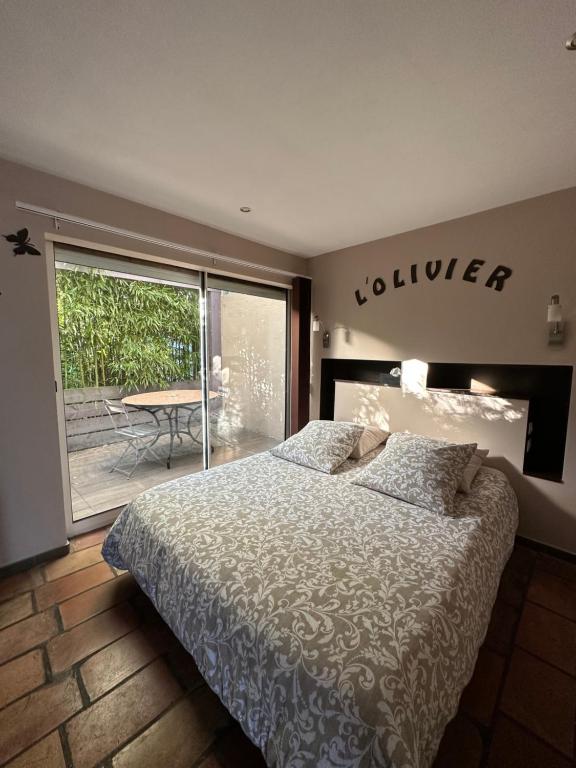 马恩河畔的尚格尼橄榄树之家住宿加早餐旅馆的一间卧室配有一张床,享有庭院的景色