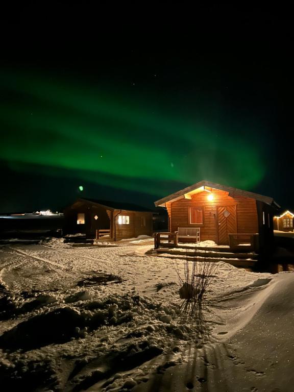 FlagbjarnarholtGuesthouse Didi的天空中绿色的北极光小屋