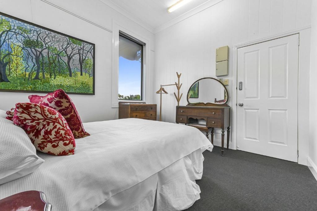 布里斯班Private Windsor House Studios Apartment的白色卧室配有床和镜子