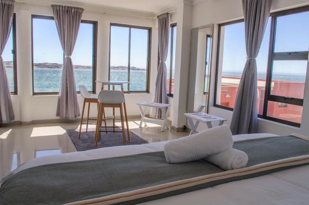吕德里茨Shark Island Guesthouse的一间卧室设有一张床,享有海景