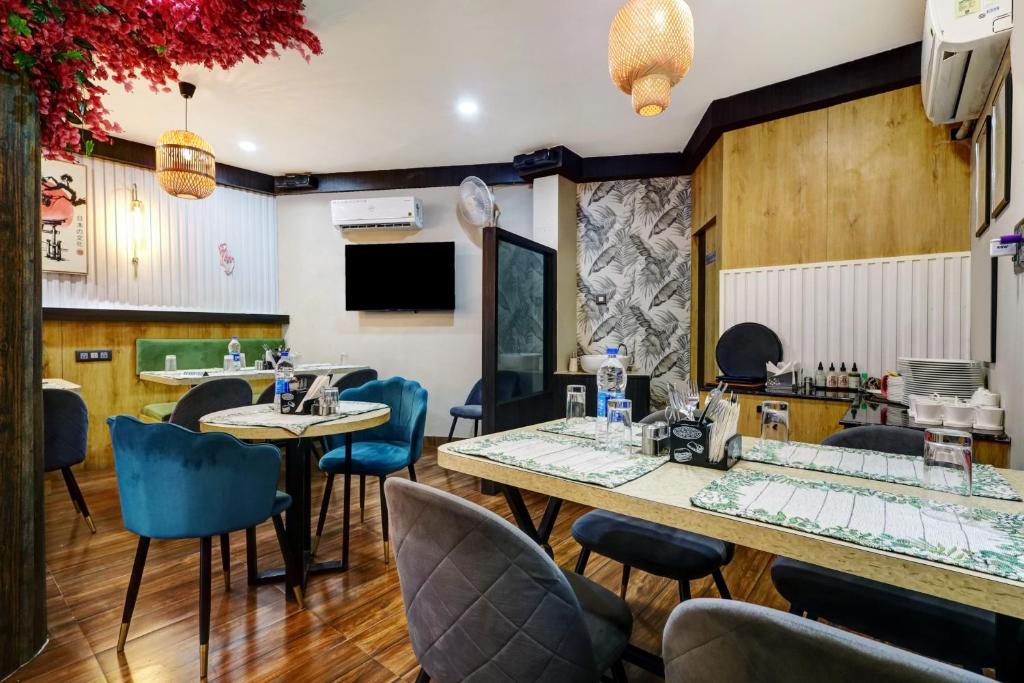 古瓦哈提Super Collection O Ashirbad Lodge的一间带桌椅的餐厅和一间酒吧