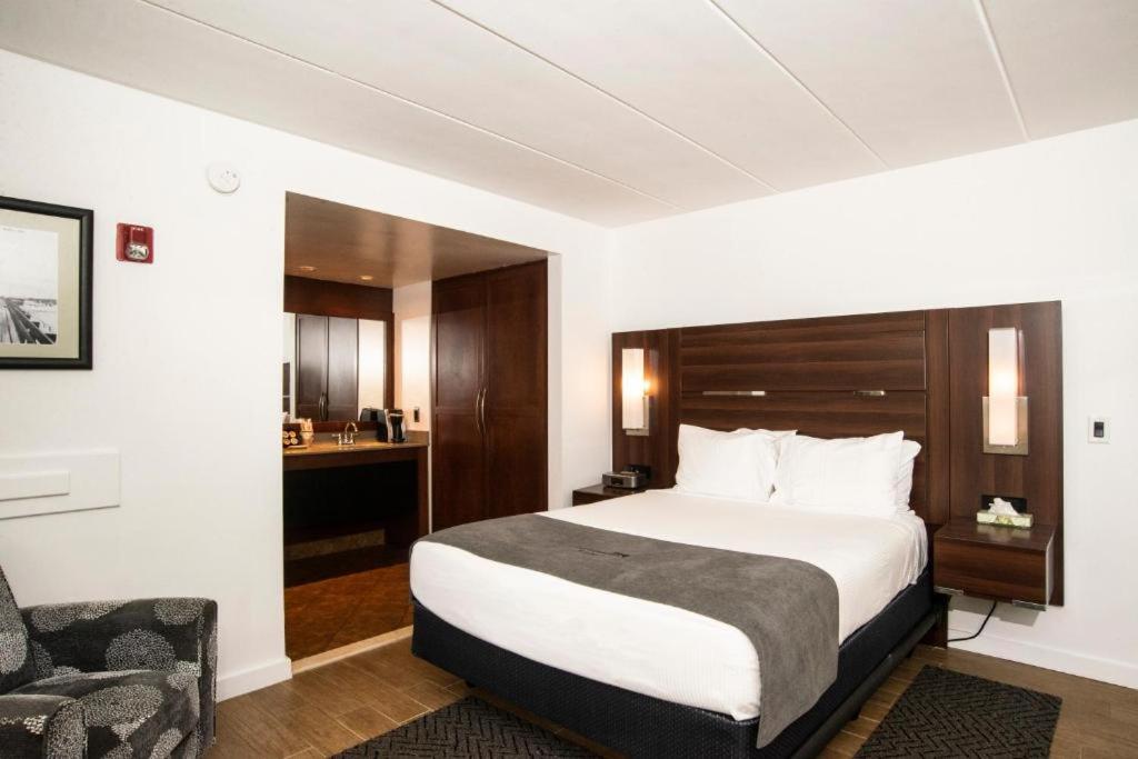 柏斯海滩侧风汽车旅馆的配有一张床和一把椅子的酒店客房