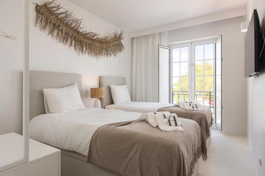 奎特里拉Modern Retreat: 3 Bedroom Villa in the Old Village的白色客房的两张床,设有窗户