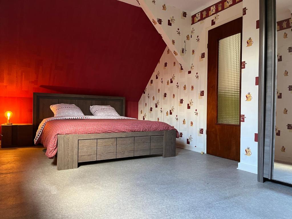布利安什维莱La Terasse des Vignes - Maison 2 Chambres - 4 Personnes的一间卧室配有一张红色墙壁的床