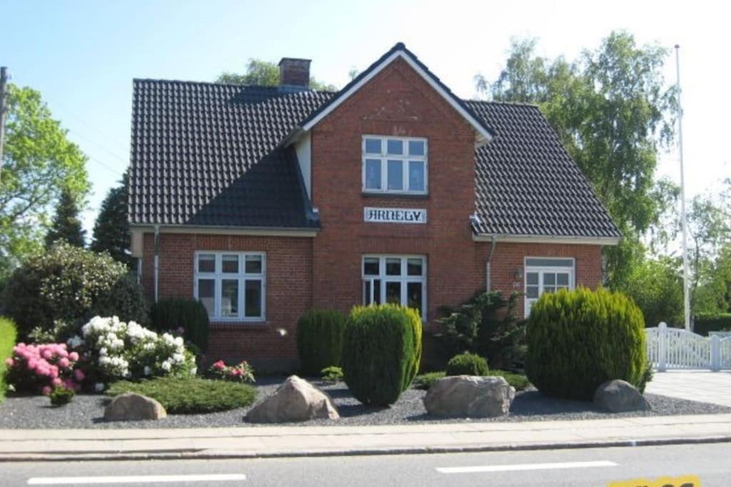 TommerupWonderful house & garden的前面有灌木丛的红砖房子