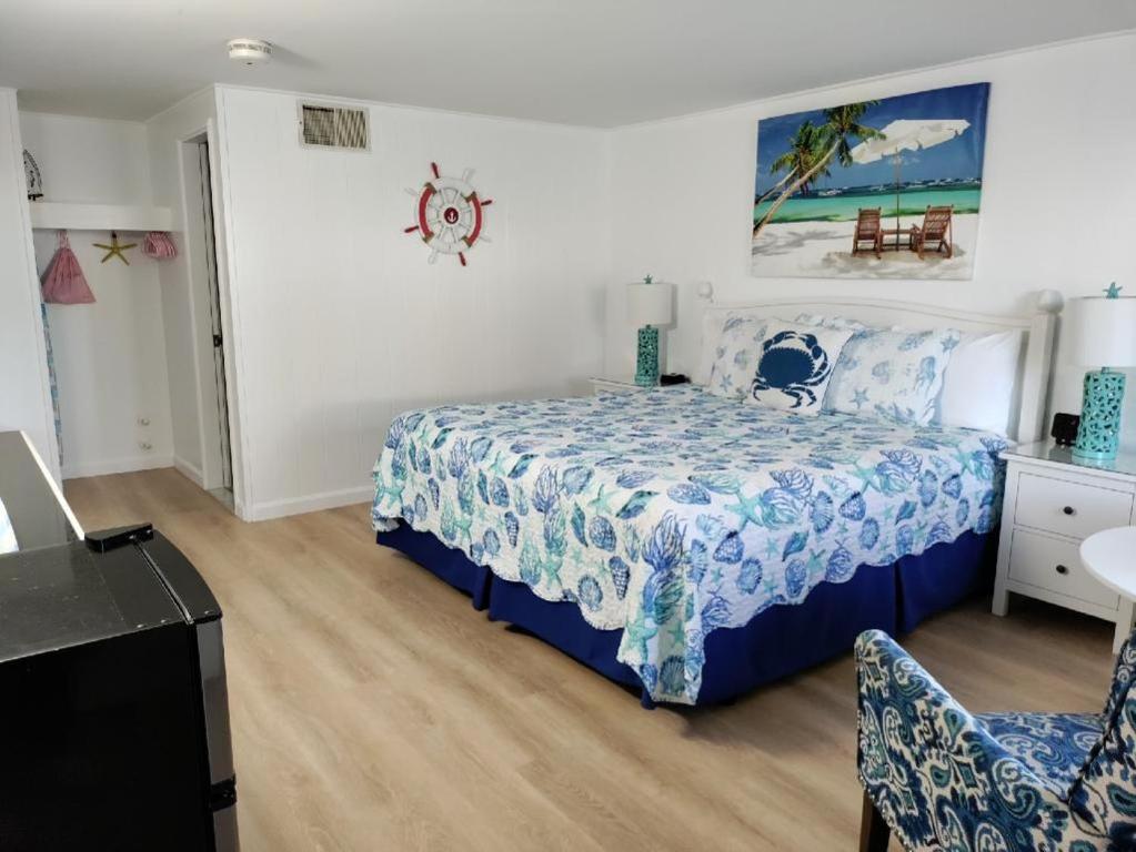 法尔茅斯水手汽车旅馆的一间卧室配有一张带蓝色和白色床单的床。