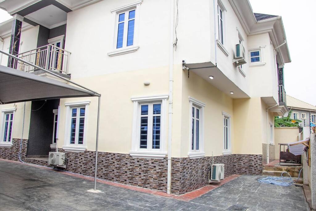 EgbaCozy Urban Oasis 3 Bedroom in Ogba, Ikeja, Lagos的街道上带窗户的大型白色建筑