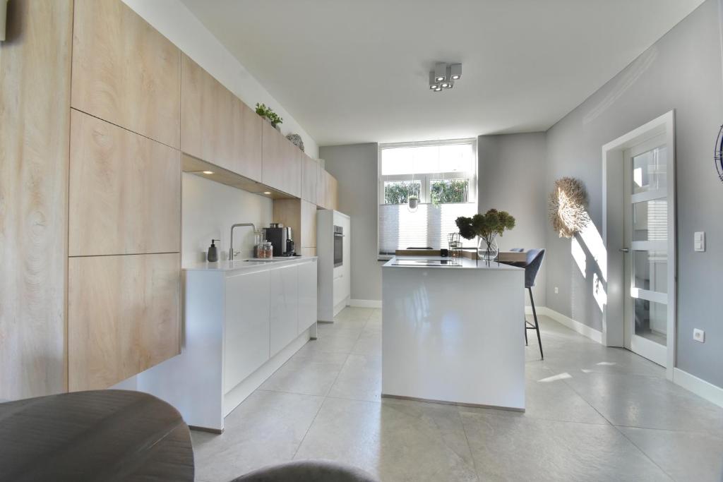 拉纳肯Stylish Home near Maastricht Alicias house的厨房配有白色橱柜和台面