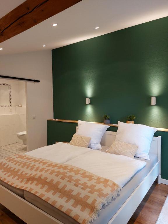 杜塞尔多夫Gut Hansenhof的一间卧室设有一张大床和绿色的墙壁