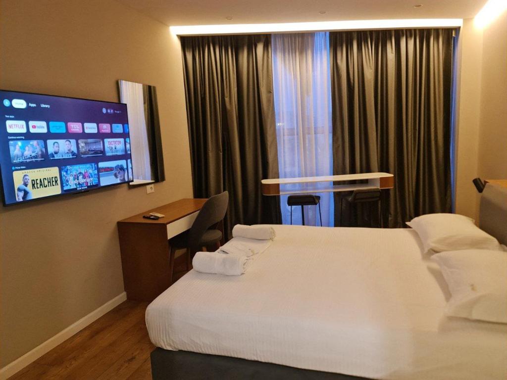 地拉那Star Hotel Astir的酒店客房设有两张床和一台平面电视。