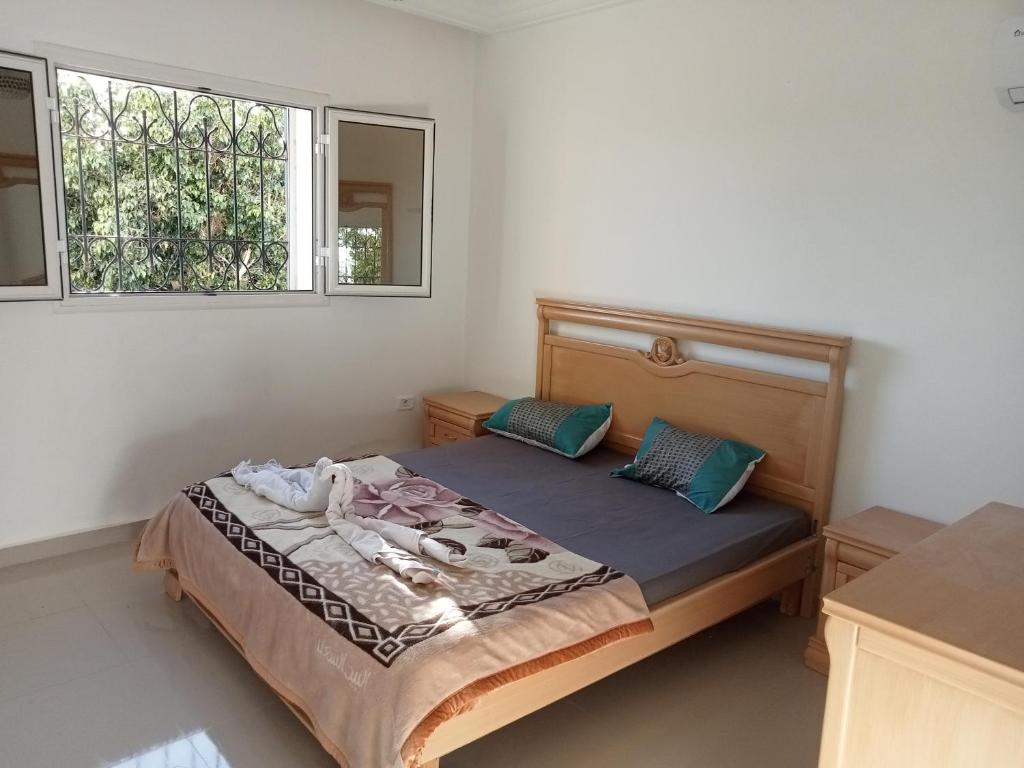 米多恩Villa Arkou Midoun的一间卧室配有带两个枕头的床和窗户