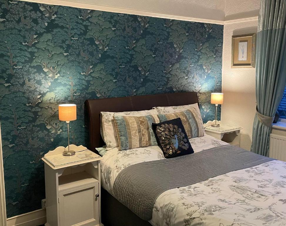 莱瑟姆-圣安妮EsJays at Knowles House的一间卧室设有一张床和绿色的墙壁