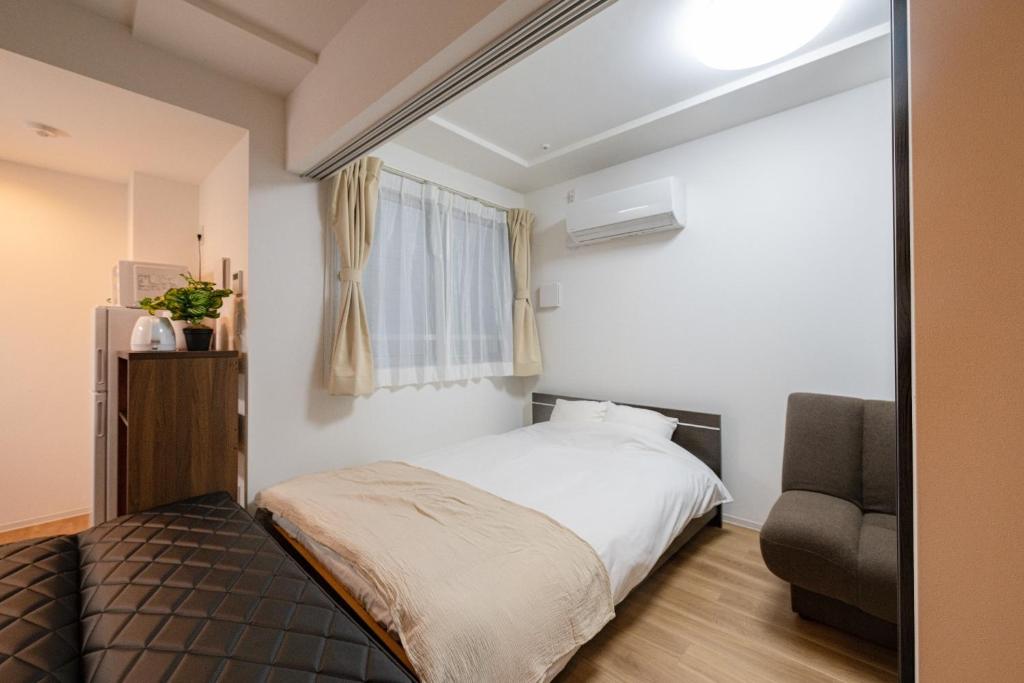 东京Repure Omori Residence - Vacation STAY 16383的一间卧室配有一张床和一把椅子