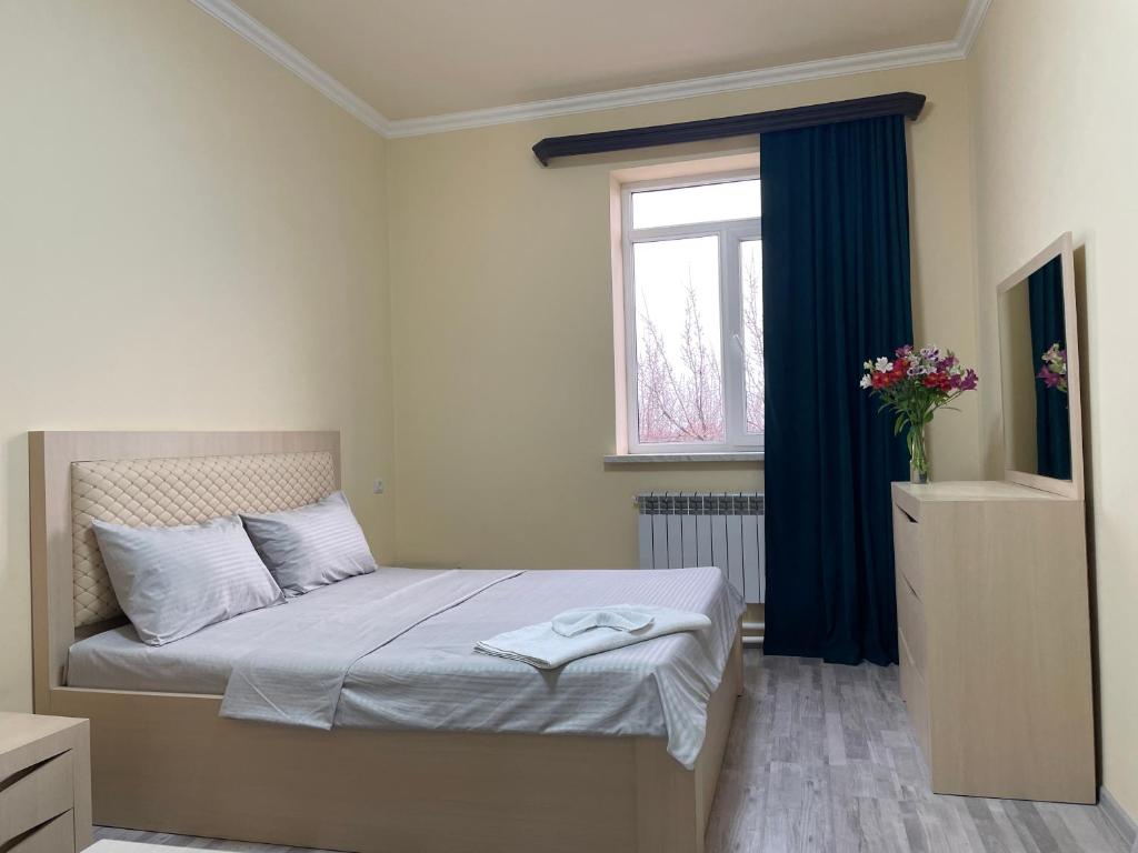 PʼarakʼarRuz & Arian的一间卧室配有一张带蓝色窗帘的床和一扇窗户