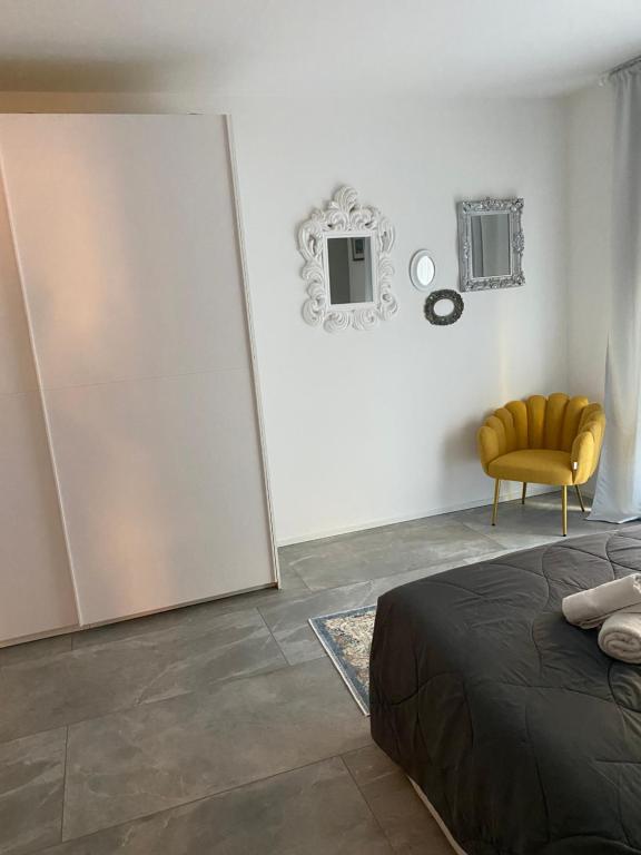 阿科Villa Romantika的一间卧室配有一张床和一张黄色椅子